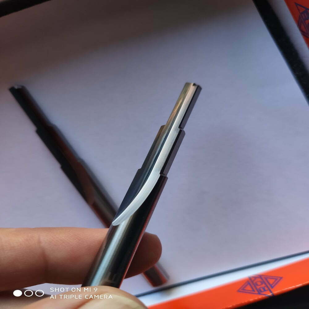 Bolígrafo metálico en primer plano, mostrando su diseño elegante y moderno con detalles en negro y plateado, sobre un fondo blanco y una caja de presentación color naranja. Ideal para regalo o uso diario.