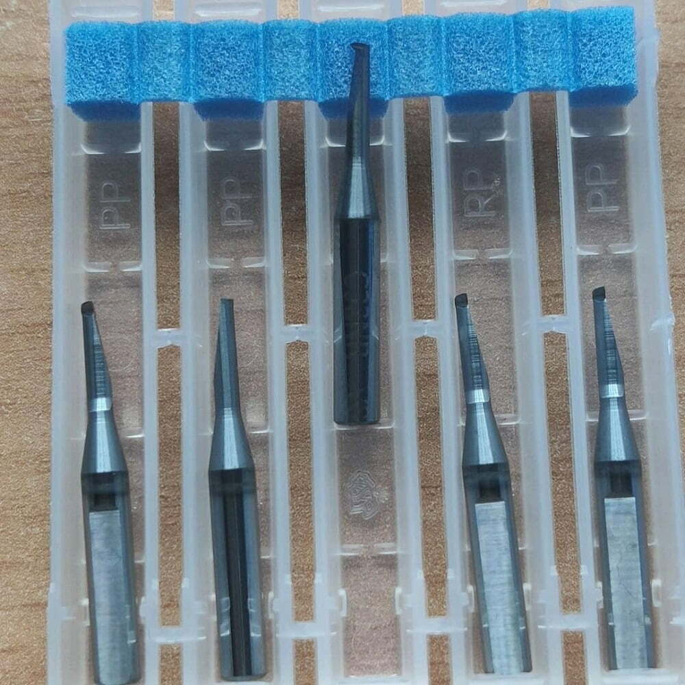 Juego de fresas de alta precisión en estuche transparente, con seis herramientas de diferentes tamaños y formas, ideales para trabajos de detallado en materiales como madera y plástico.
